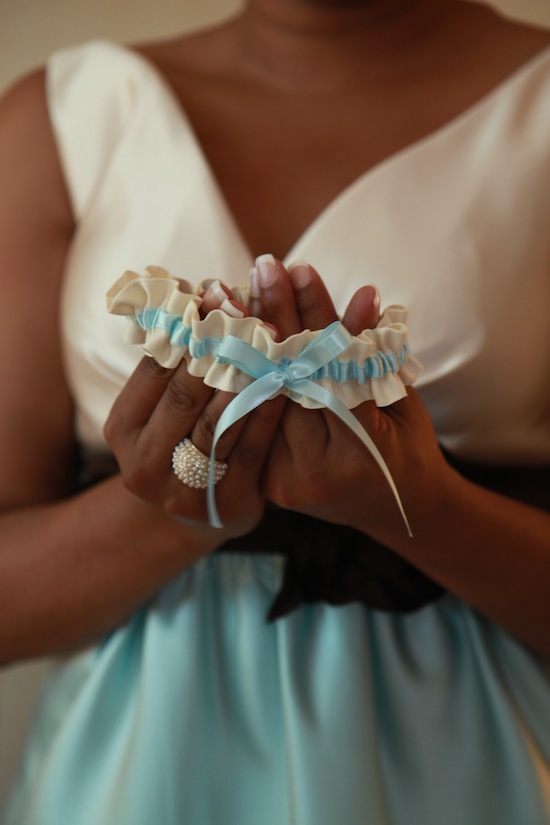 bridesmaid-holding-blue-wedding-garter by LucieXYZ Photography