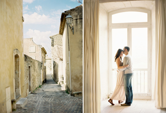 Charming couple embraces by window, quaint European alleyway beside