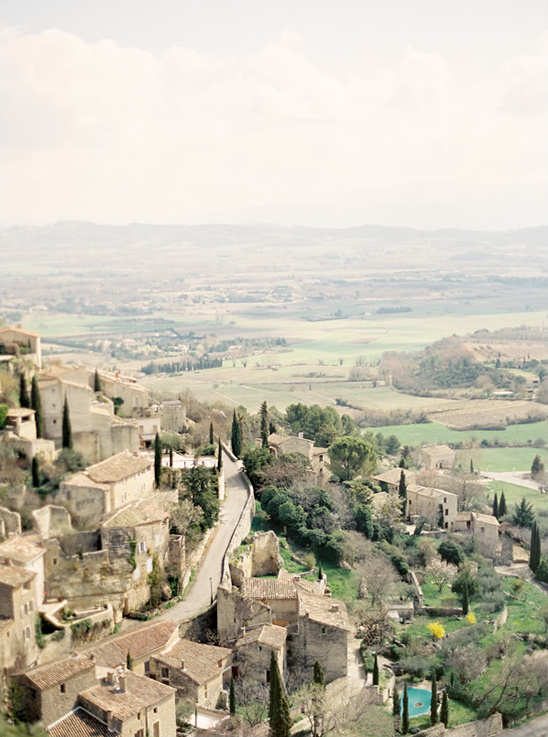 Scenic view of a village nestled in the hills, overlooking a green valley