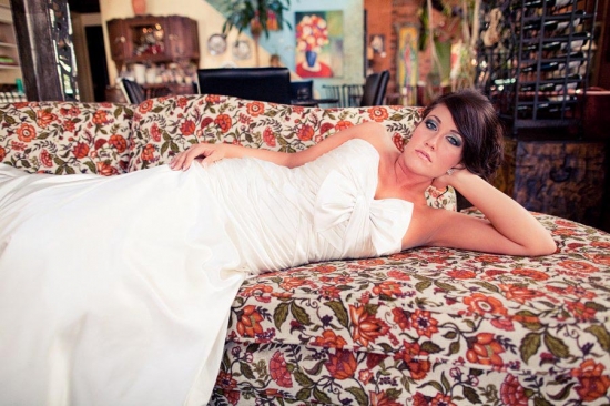 Bride in white gown relaxing on floral couch