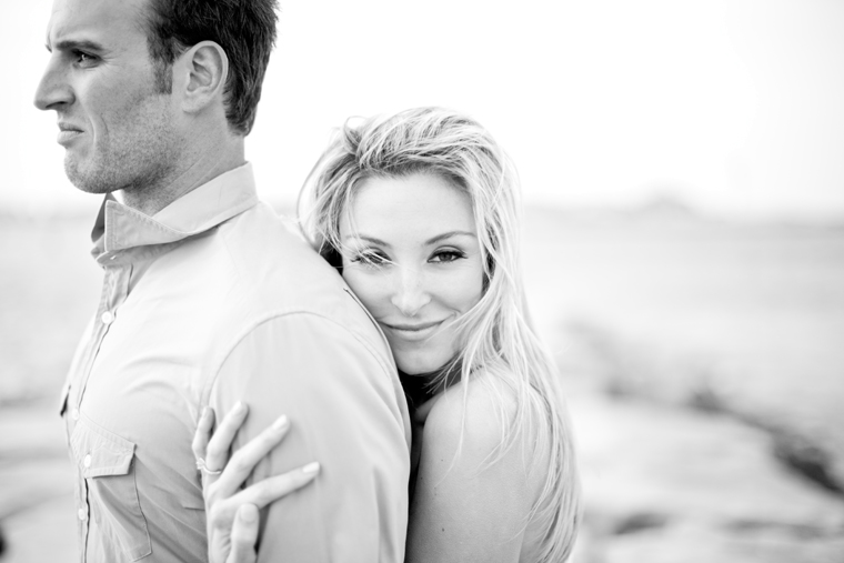 Loving woman embraces her handsome partner in black and white