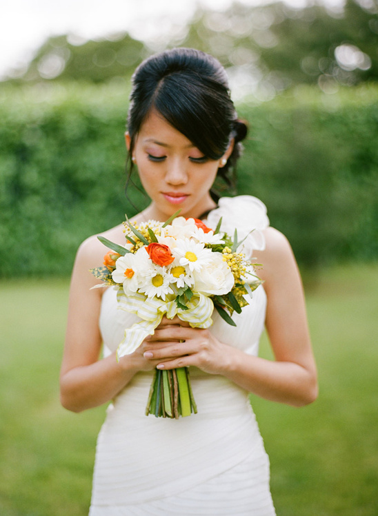 Asian bride holding white and yellow wedding bouquet
