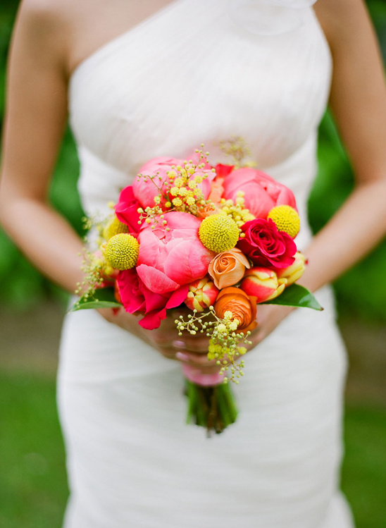 Bride holding vibrant pink and orange wedding bouquet