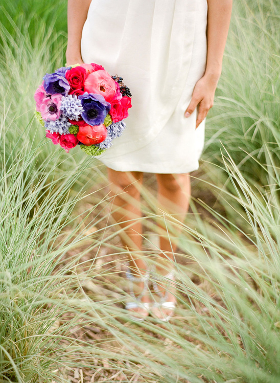 Bride holding vibrant pink and purple wedding bouquet