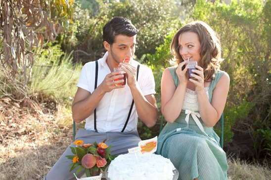 Young couple enjoying drinks and cake outdoors