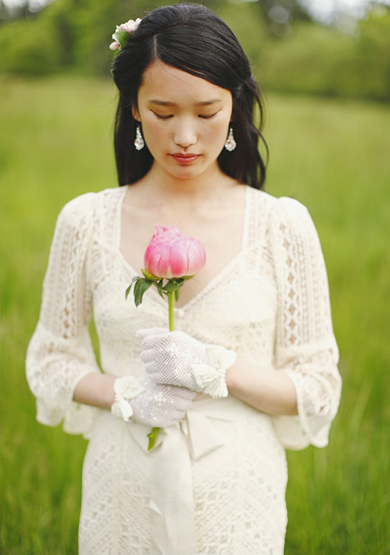 Woman in lace dress holding pink flower