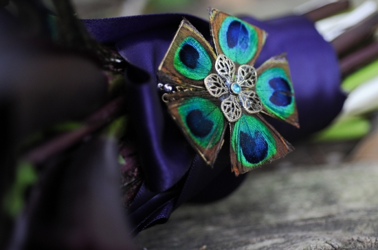 Peacock feather brooch on purple bouquet
