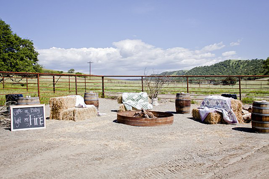 Rustic outdoor fire pit area with hay bale seating