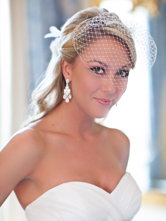 Blonde bride in white dress and birdcage veil