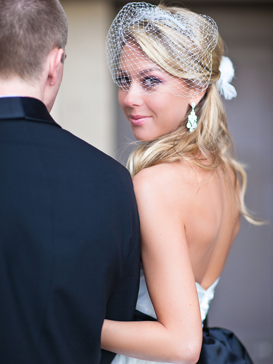 Bride wearing veil with groom on wedding day