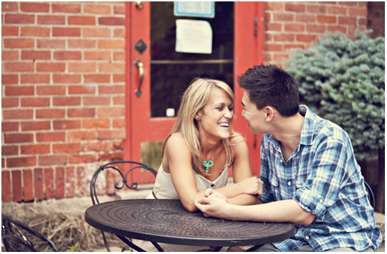 Happy couple laughing together at outdoor cafe table