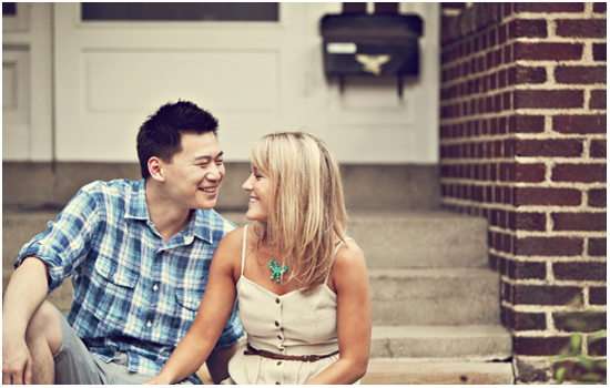 Happy couple sitting on steps, smiling at each other