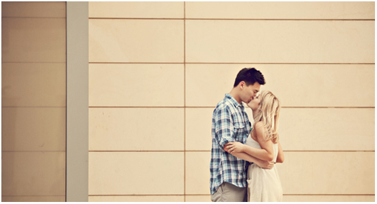 A young couple sharing a kiss outdoors on city street