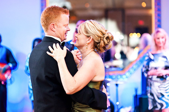 Couple smiles while dancing at a formal event