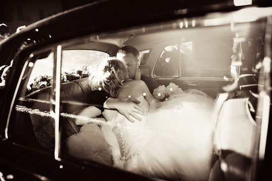 Newlyweds share a kiss in the backseat of their car