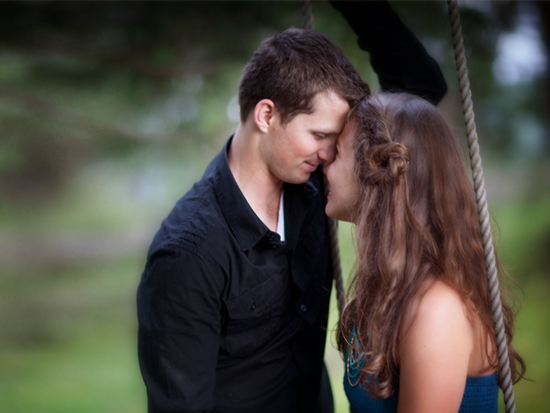 Couple close faces on swing
