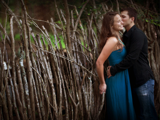 Couple embracing romantically by a wooden fence