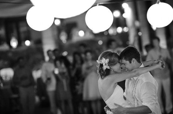 Bride and groom share first dance under lights