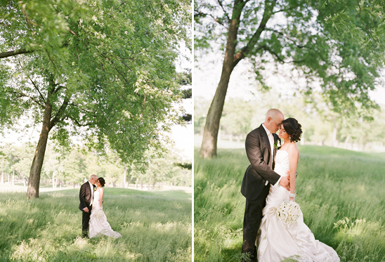 Happy couple embracing under a tree on their wedding day