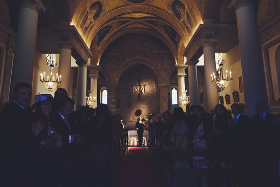 Wedding guests in church with ornate arched ceiling