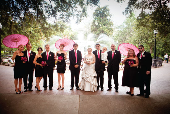 Wedding party with pink accents and parasols outdoors
