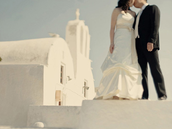 Santorini wedding kiss against white buildings