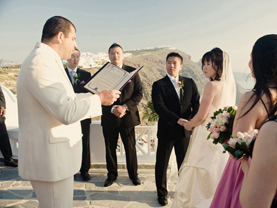 Asian couple exchanging vows during outdoor wedding
