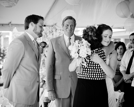 Bride hugs mother at wedding ceremony grayscale image