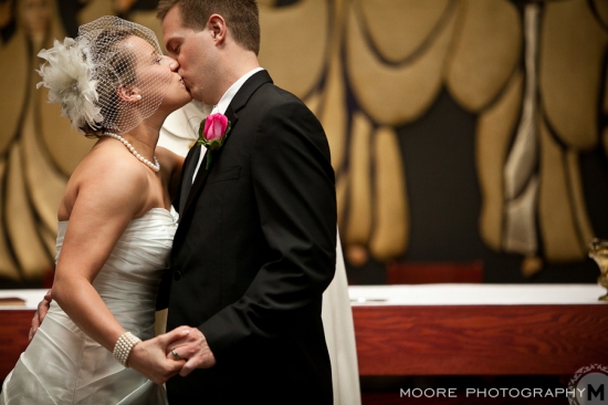Newlyweds sharing a tender kiss at their wedding ceremony