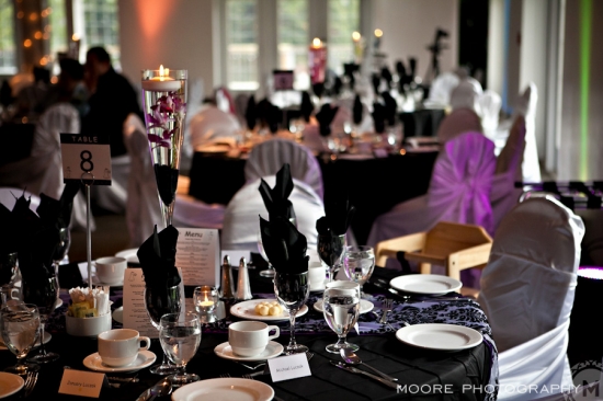 Elegant wedding reception table decor with black and purple accents