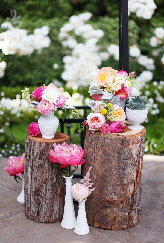 Pretty floral arrangements on rustic wooden logs