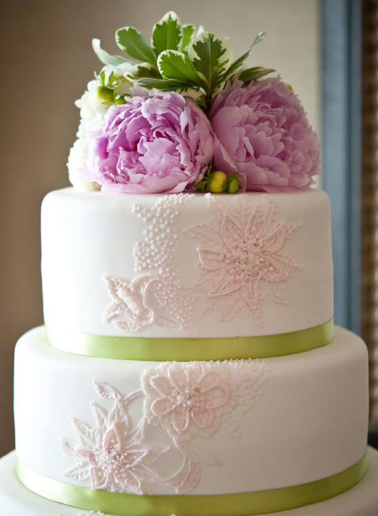 Elegant two-tiered wedding cake with pink peonies