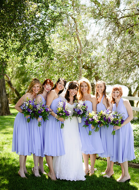 Bride and bridesmaids in lilac dresses outdoors