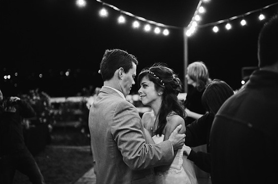 Romantic couple dancing under string lights at night