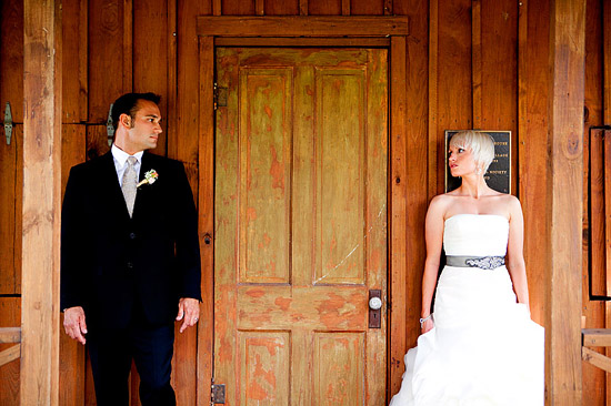 Couple in wedding attire by rustic wooden door