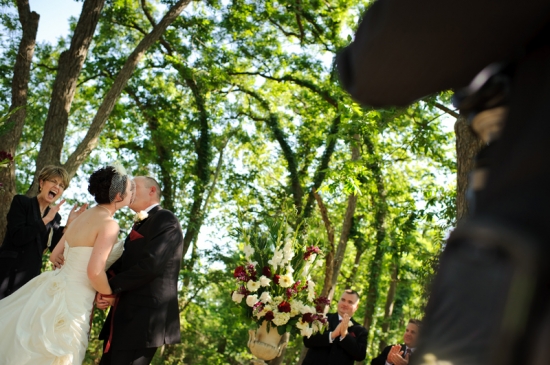 Couple kissing outdoors at wedding ceremony