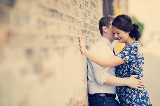 Romantic couple embracing near brick wall