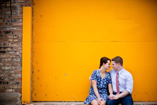 Romantic couple embracing against vibrant yellow wall