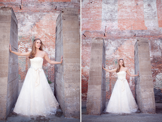 Bride in wedding gown poses between concrete pillars