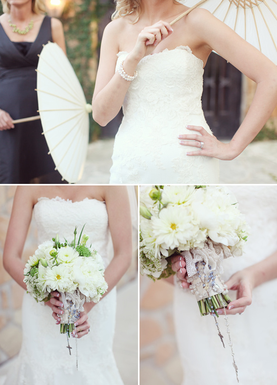 Bride in lace dress holding bouquet and parasol