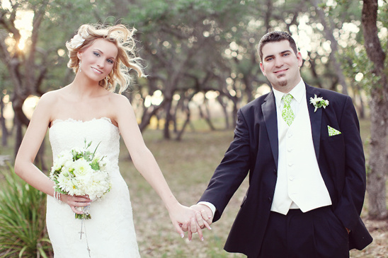 Happy bride and groom holding hands outdoors