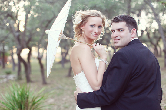 Bride and groom portrait with parasol outdoors