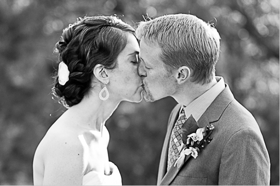 Bride and groom sharing a tender wedding kiss