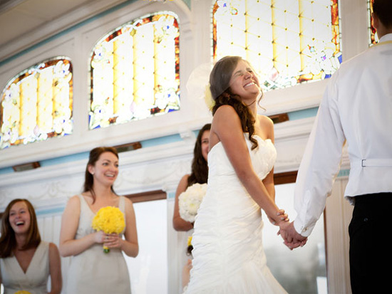 Bride joyfully holds hands at wedding ceremony