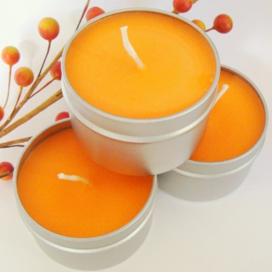 Three orange tin candles with berry accents