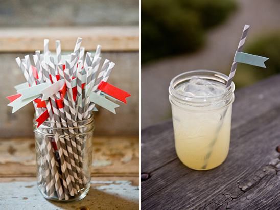 Striped straws in a mason jar and a drink on wood table