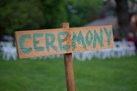 Handmade wooden ceremony sign at an outdoor event