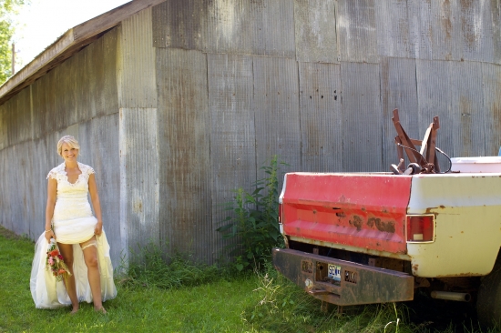 Bride in rustic wedding dress near vintage truck