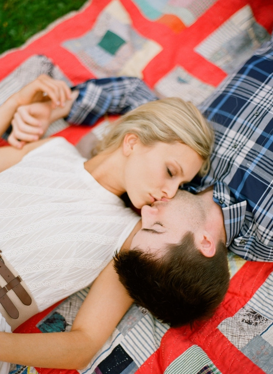 Couple kissing on patchwork blanket