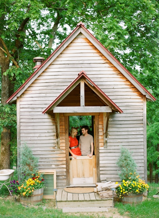 Couple in front of rustic wooden cabin